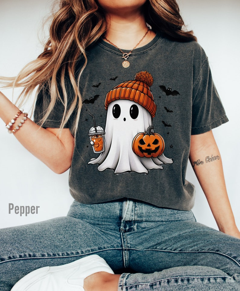 a woman wearing a halloween t - shirt with a ghost on it