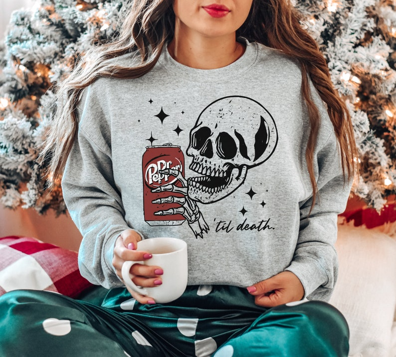 a woman sitting on a couch holding a cup of coffee