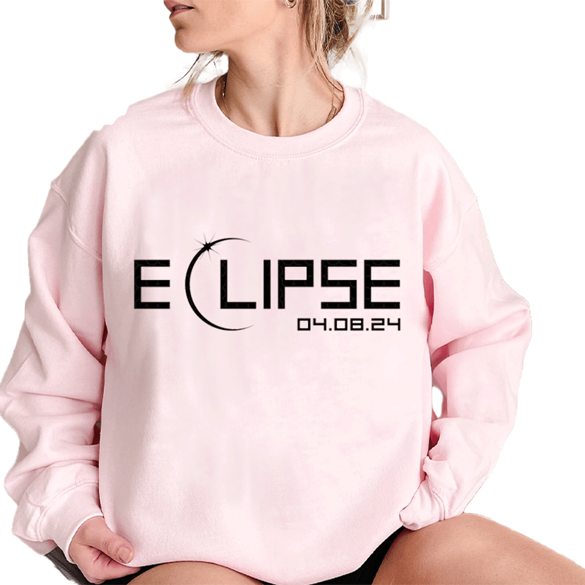 a woman wearing a pink sweatshirt with the word eclipse printed on it