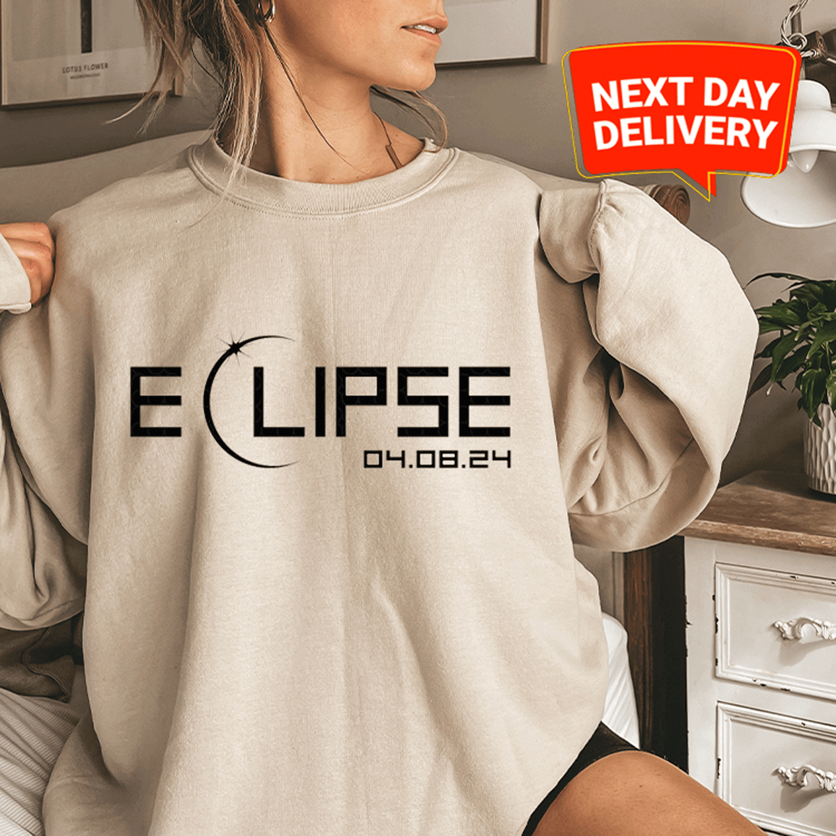 a woman sitting on a bed wearing a sweatshirt that says eclipse