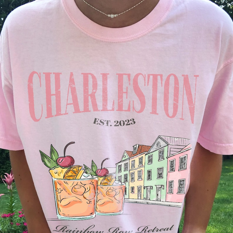 a person wearing a pink shirt with a picture of two drinks on it